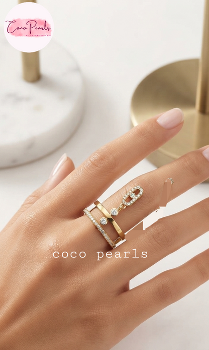 Coco pearls stainless Steel anti tarnish close-up of a hand wearing three stacked rings by Coco Pearls, featuring gold bands with clear pavé and diamond accents, set against a soft, light background