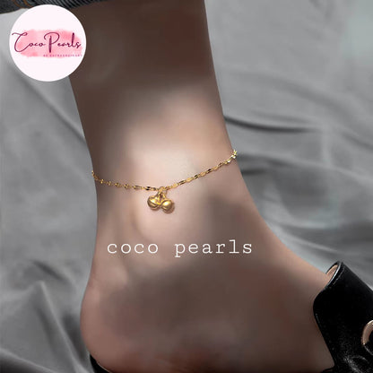 Coco pearls stainless Steel anti tarnish delicate gold chain anklet with two small bead-like bell charms is shown worn on a person's ankle.