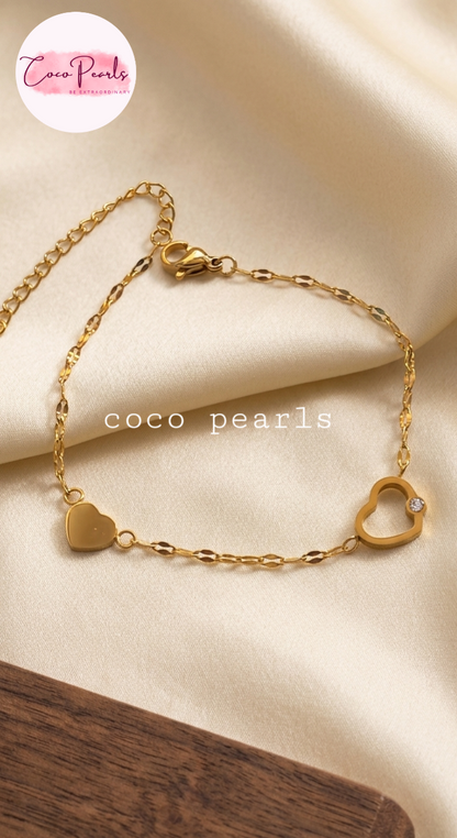Coco pearls stainless Steel anti tarnish Gold bracelet with heart-shaped links on a beige fabric background, 