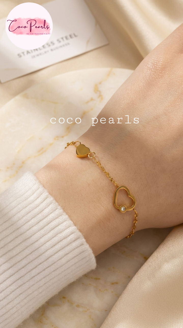 Coco pearls stainless Steel anti tarnish gold rwin heart whisper bracelet with two hearts linked displayed on simple background 