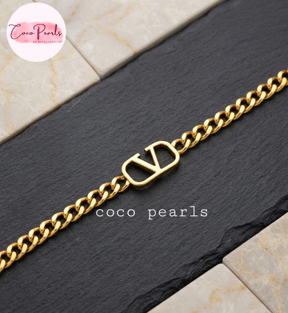 Coco pearls stainless Steel anti tarnish gold  v curb bracelet with thick chain displayed on grey background 