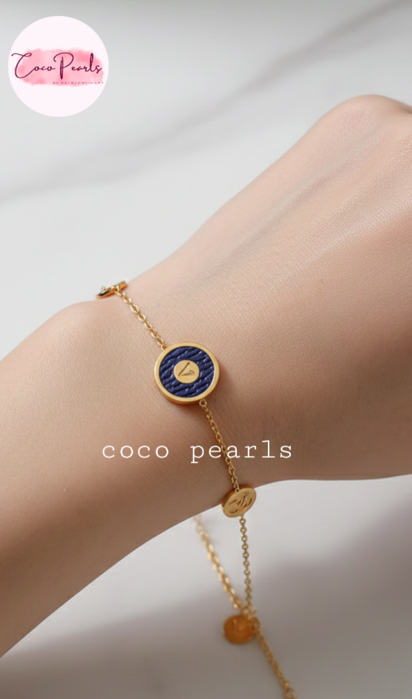 Coco Pearls Stainless Steel Anti tarnish Gold and brown v link bracelet with v initial on brown charm in center and golden charms on either side displayed on hand