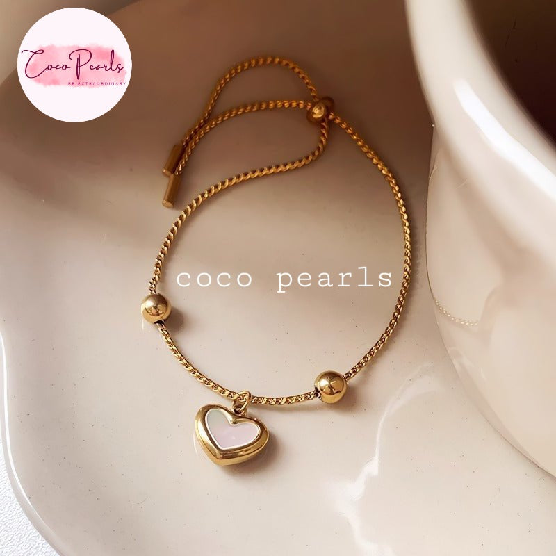 Coco pearls stainless Steel anti tarnish gold wish heart bracelet with white heart charm displayed on simple background