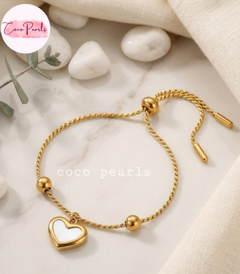 Coco pearls stainless Steel anti tarnish gold  wish heart bracelet with white heart charm in center displayed on simple background 