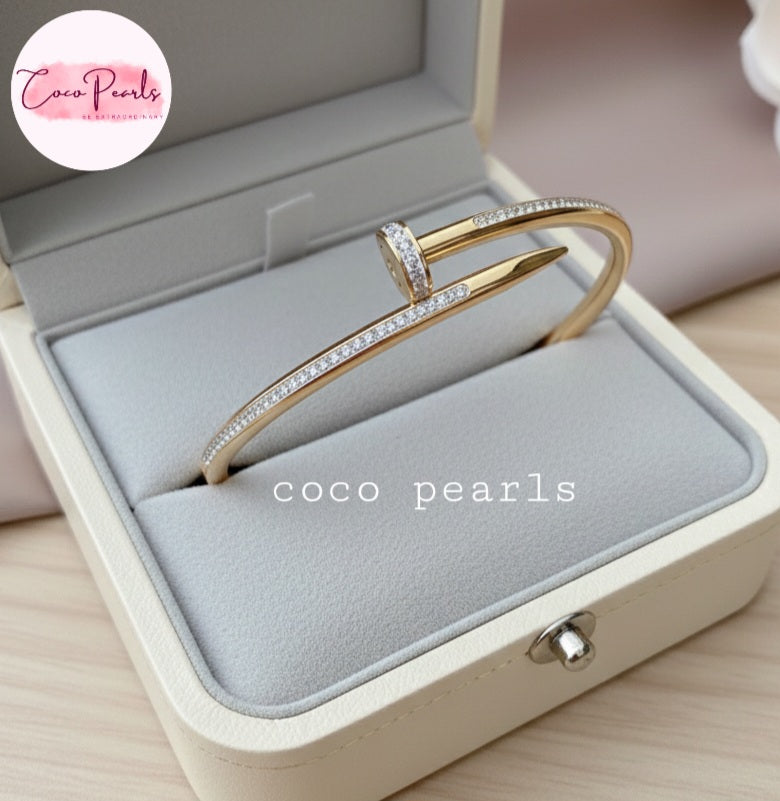 Coco Pearls Stainless Steel Anti Tarnish Gold Aurora nail handcuff diamonds studded on nail design handcuff on a jewelry box.