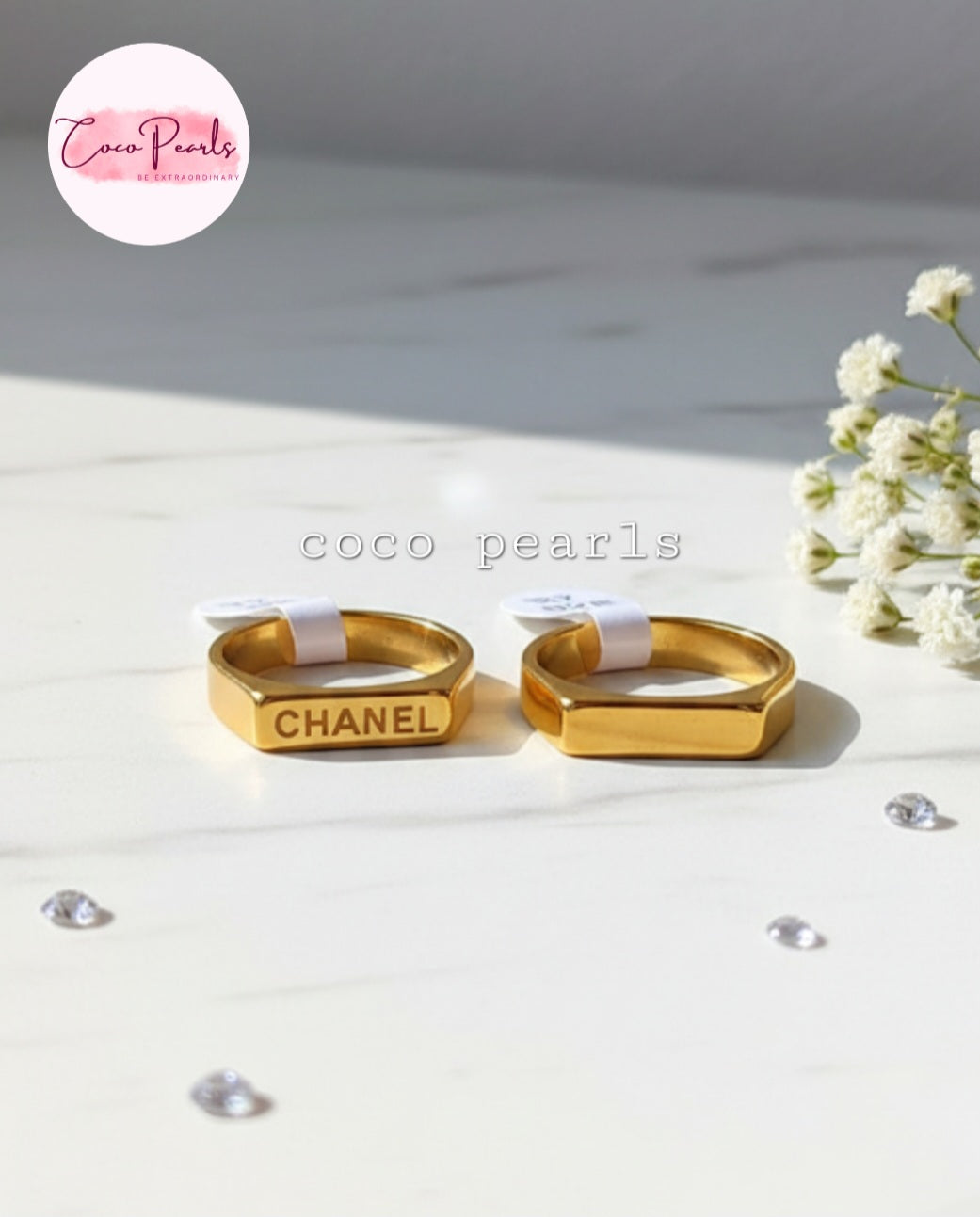 Coco Pearls Stainless Steel Anti Tarnish Gold aurum link ring with  Chanel written on a marble surface 
