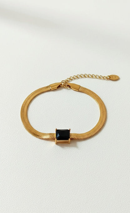 Coco Pearls Stainless Steel Anti Tarnish Gold black accent bracelet with a black gemstone on a white background