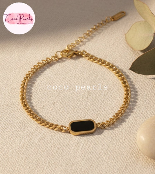 Coco Pearls stainless steel Anti Tarnish Gold black onyx chain bracelet with a black clasp on a wrist
