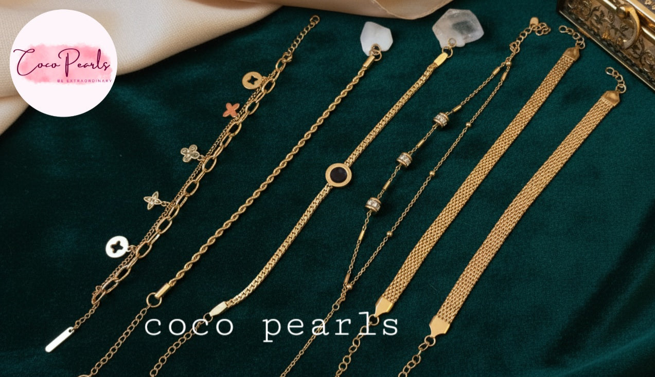 Coco Pearls Stainless steel anti tarnish Gold bracelets on a dark green surface.