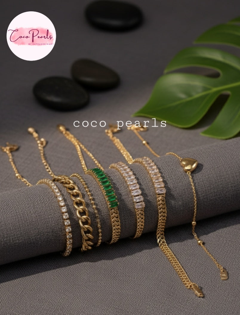 Coco Pearls Stainless steel Anti Tarnish Gold bracelets with different bracelets stacked on a grey background