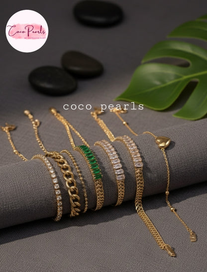 Coco Pearls Stainless steel Anti Tarnish Gold bracelets with different bracelets stacked on a grey background