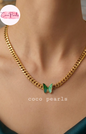 coco pearls stainless steel anti tarnish Gold chain necklace with a green butterfly pendant on a person's neck