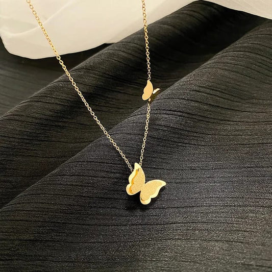 Coco Pearls Stainless Steel Anti Tarnish Gold butterfly duo necklace on a black fabric background