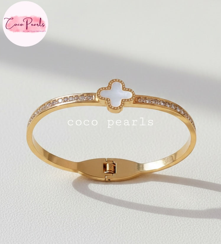 Coco Pearls Stainless Steel Anti tarnish gold clover luxe handcuff with zircon studded on sides and clover in center displayed on white background