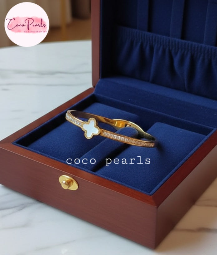 Coco Pearls Stainless Steel Anti tarnish gold clover luxe handcuff with zircon on sides and clover in center displayed on jewelry box