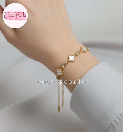 Coco Pearls Stainless Steel Anti Tarnish Gold clover tube bracelet with clover and tube charms on a wrist.
