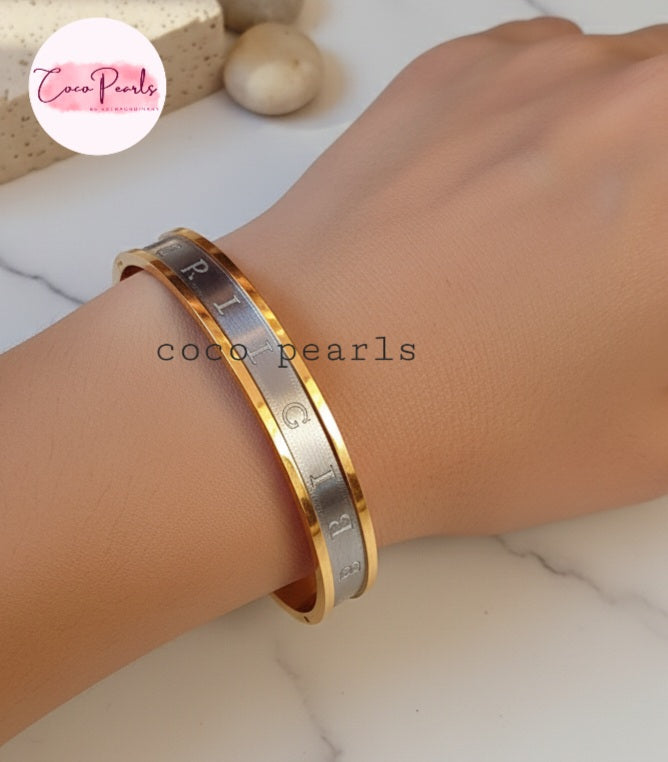 Coco Pearls Stainless Steel Anti Tarnish Gold and silver coco glitz bangle bracelet on a wrist.