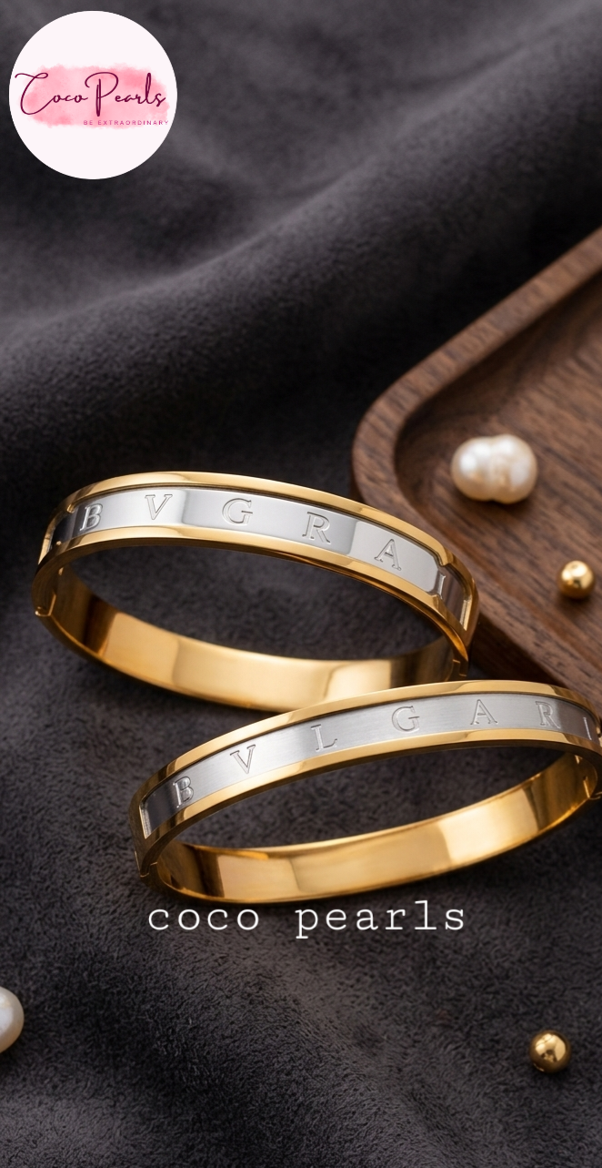 Coco Pearls Stainless Steel Anti Tarnish Two coco glitz gold handcuff bracelets with engraved text on a dark background