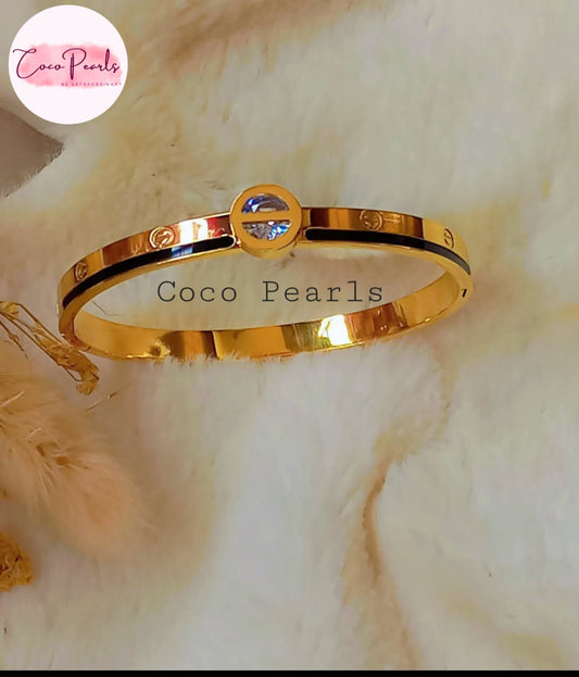 Coco Pearls Stainless Steel Anti Tarnish Gold coco loop handcuff bangle bracelet with a central gemstone on a white background