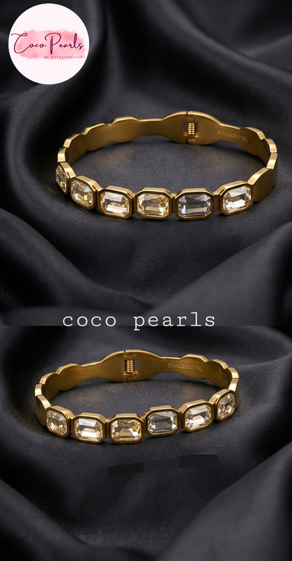 Coco Pearls Stainless Steel Anti Tarnish Gold crystal glam handcuff bangle bracelet with rectangular clear stones on a dark surface