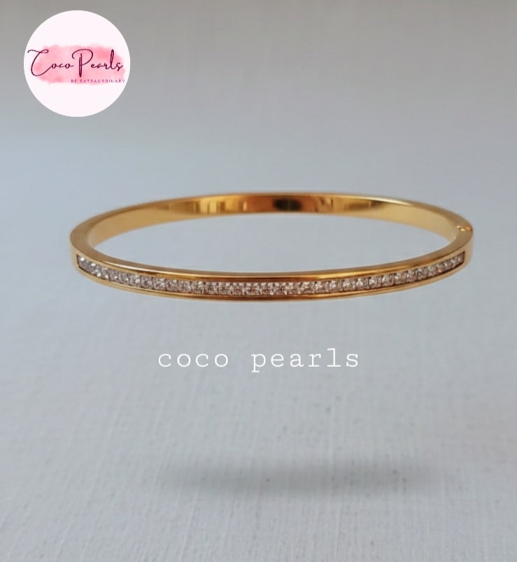 Coco Pearls Stainless Steel Anti tarnish Gold crystal shine handcuff  bracelet with small stones on a light gray background