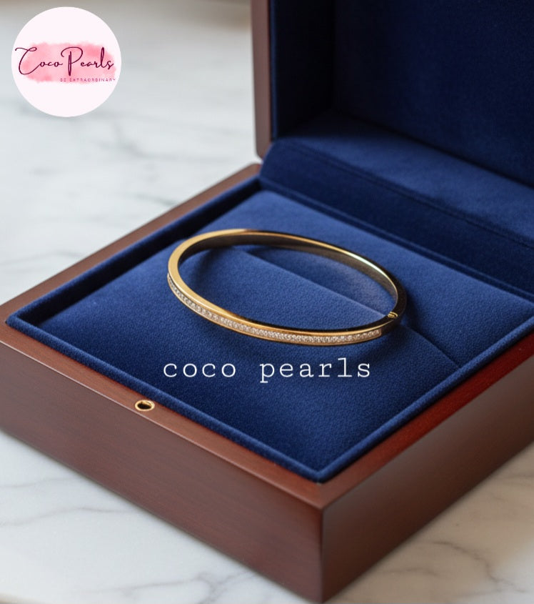 Coco Pearls Stainless Steel Anti tarnish Gold crystal shine handcuff bracelet in a blue jewelry box 