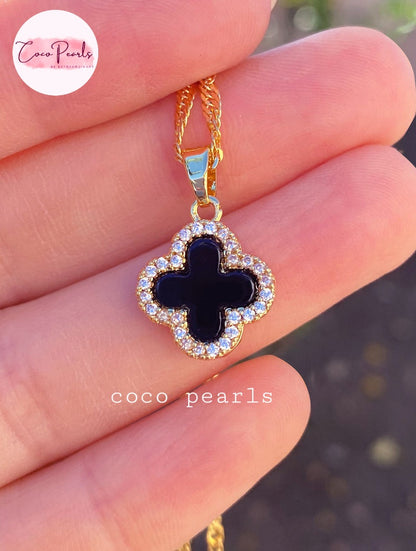 Coco Pearls Stainless Steel Anti Tarnish Two sided diamond studded gold necklaces with clover-shaped pendants one side black one side white on hand
