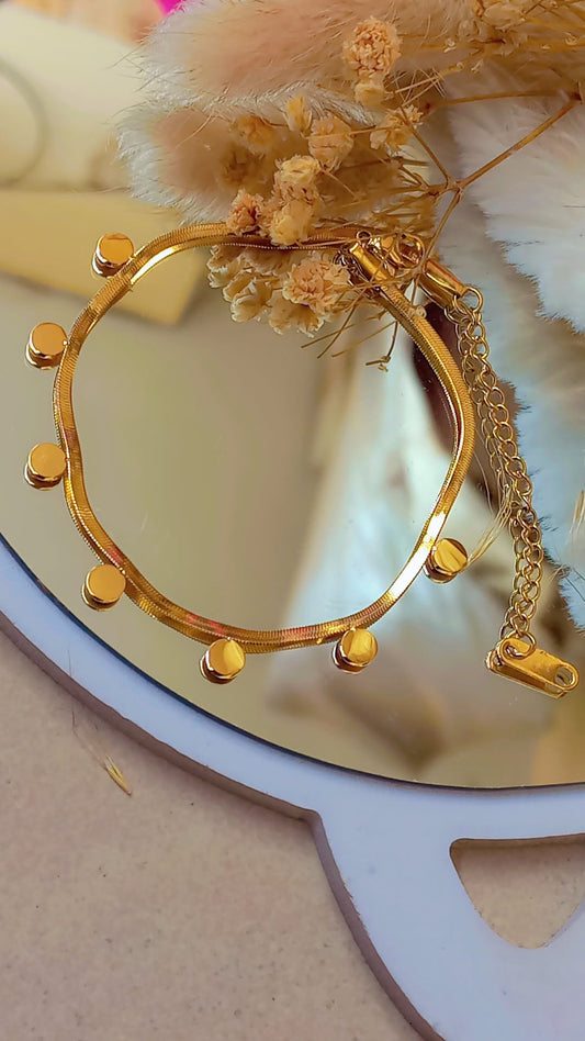 Coco Pearls Stainless Steel Anti Tarnish Gold dainty disc bracelet with  gold discs on snake chain with dried flowers on a decorative plate