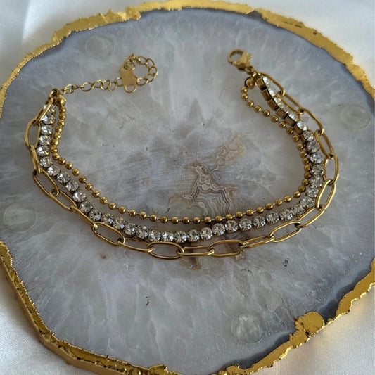 Coco Pearls Stainless Steel Anti Tarnish Gold chain and crystal bracelet on a gray stone surface