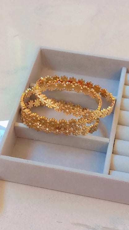 Coco Pearls Stainless Steel Anti Tarnish Gold daisy bloom floral bangle bracelet in a jewelry box on a light background