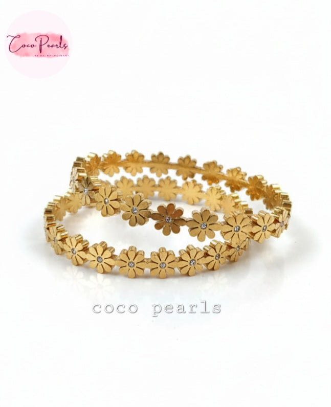 Coco Pearls Stainless Steel Anti Tarnish Gold daisy bloom floral bangle bracelet. Set of gold floral bangleson a white background