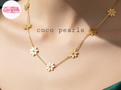 Coco Pearls Stainless Steel Anti Tarnish Gold daisy bloom necklace with flower pendants on a person wearing a green top