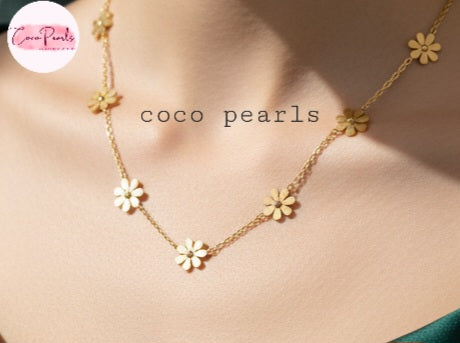 Coco Pearls Stainless Steel Anti Tarnish Gold daisy bloom necklace with flower pendants on a person wearing a green top