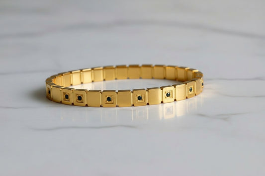 Coco Pearls Stainless Steel Anti Tarnish Gold daisy gold handcuff bangle bracelet with diamond studded square links on a white fur background