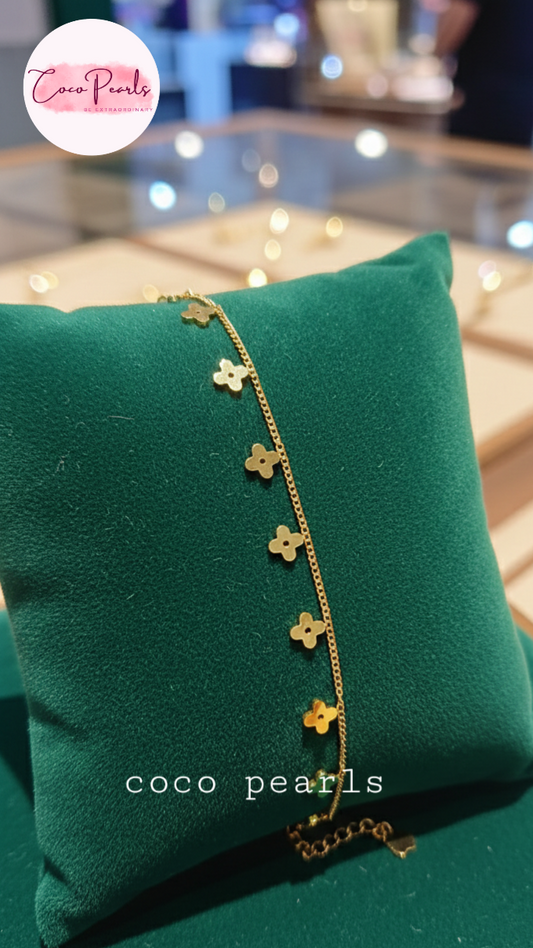 Gold bCoco Pearls Stainless Steel Anti Tarnish Gold delight anklet with clover-shaped charms on a green pillow