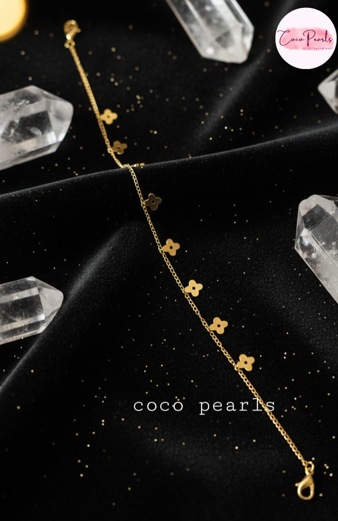Coco Pearls Stainless Steel Anti Tarnish Gold delight anklet with flower-shaped clasps on a black background
