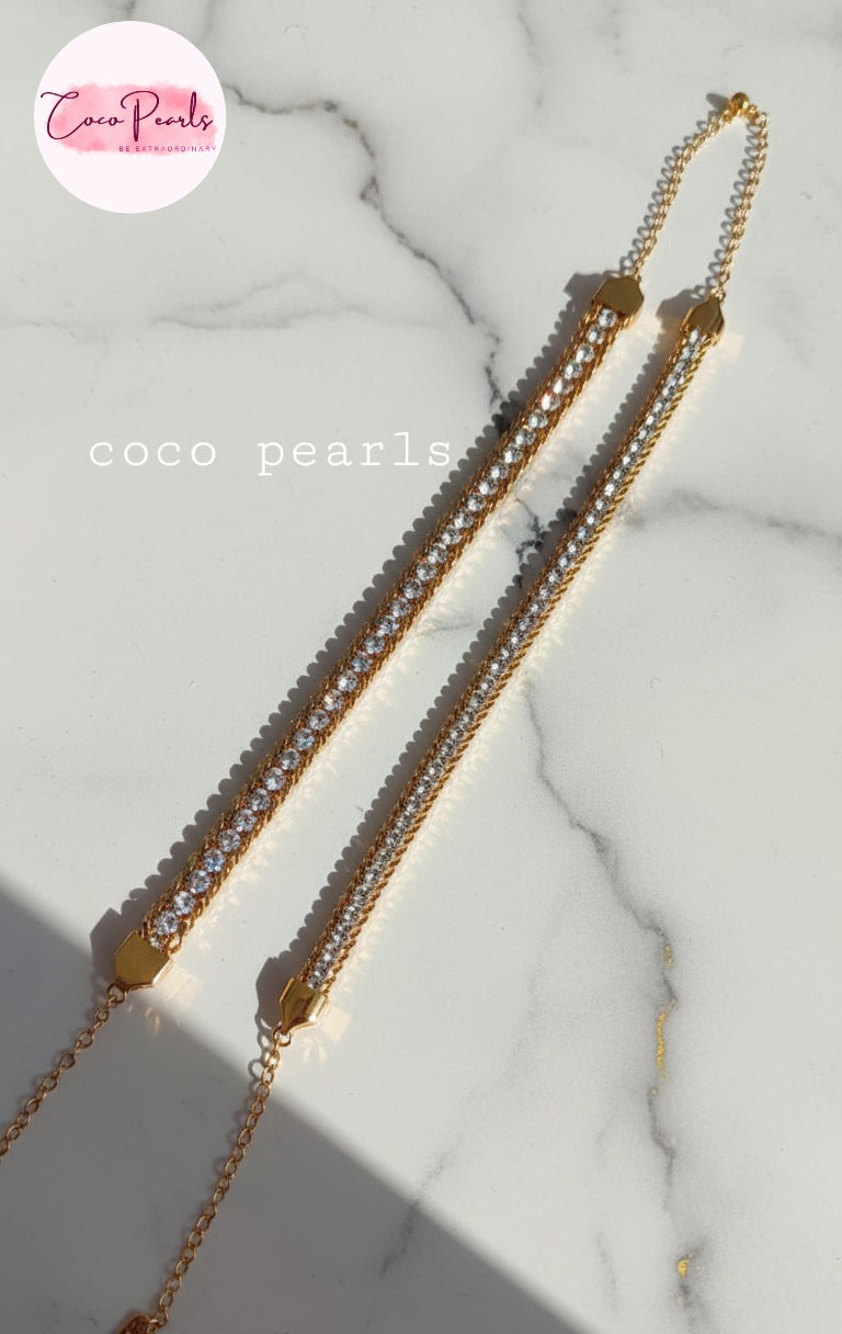 Coco Pearls Stainless Steel Anti Tarnish Gold bracelet with embedded stones on a marble surface one broad chain other medium chain