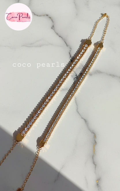 Coco Pearls Stainless Steel Anti Tarnish Gold bracelet with embedded stones on a marble surface one broad chain other medium chain