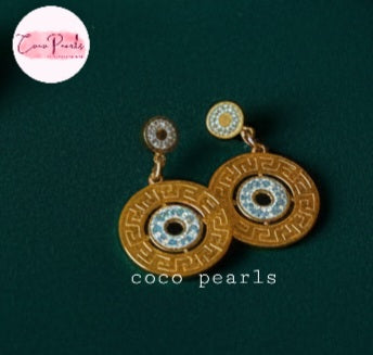 Coco Pearls Stainless Steel Anti Tarnish Gold diamond in motion earrings with gold discs diamond studded on a dark green background