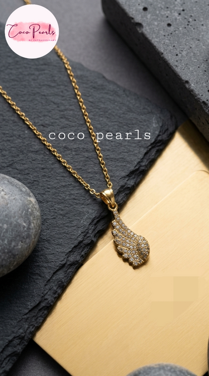 coco pearls stainless steel pakistan anti tarnish waterproof Gold diamond wing necklace with diamond studded wing pendant on a dark background
