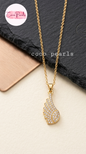 coco pearls stainless steel pakistan anti tarnish waterproof Gold diamond wing necklace with diamond studded wing pendant on a light background