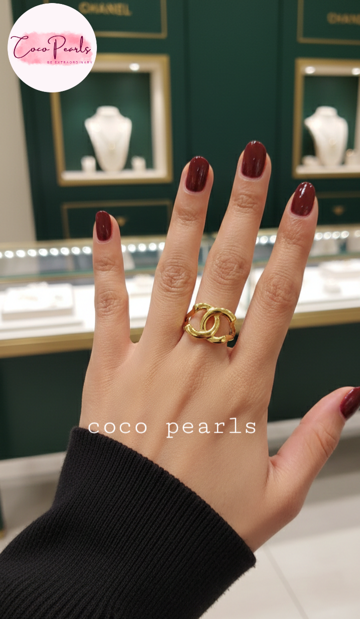 coco pearls stainless steel anti tarnish Hand wearing a gold ring with displayed in front of a jewelry store display.