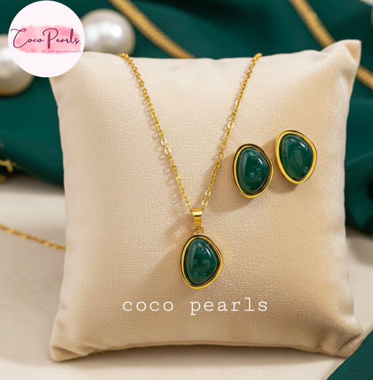 coco pearls stainless steel anti tarnish gold Jewelry set with green gemstones and gold accents on a beige pillow