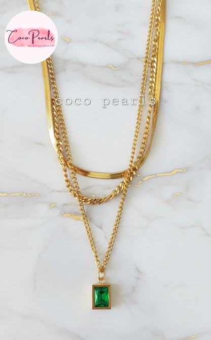 Coco Pearls Stainless Steel Anti Tarnish Gold emerald trio triple chain necklace with a green pendant displayed on marble surface