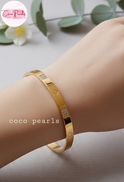 Coco Pearls Stainless Steel Anti tarnish Gold Gleam Hinged Handcuff Bangle bracelet displayed on a wrist