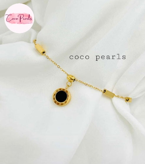 Coco Pearls Stainless steel anti tarnish Gold geometry bracelet with black gemstone hanging displayed on a white background,