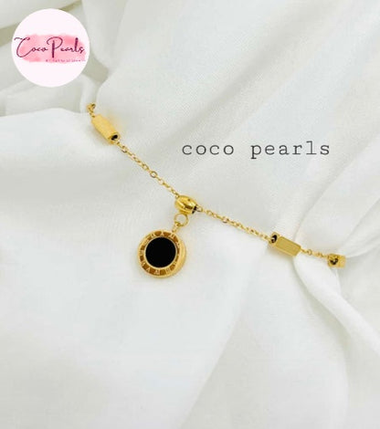 Coco Pearls Stainless steel anti tarnish Gold geometry bracelet with black gemstone hanging displayed on a white background,