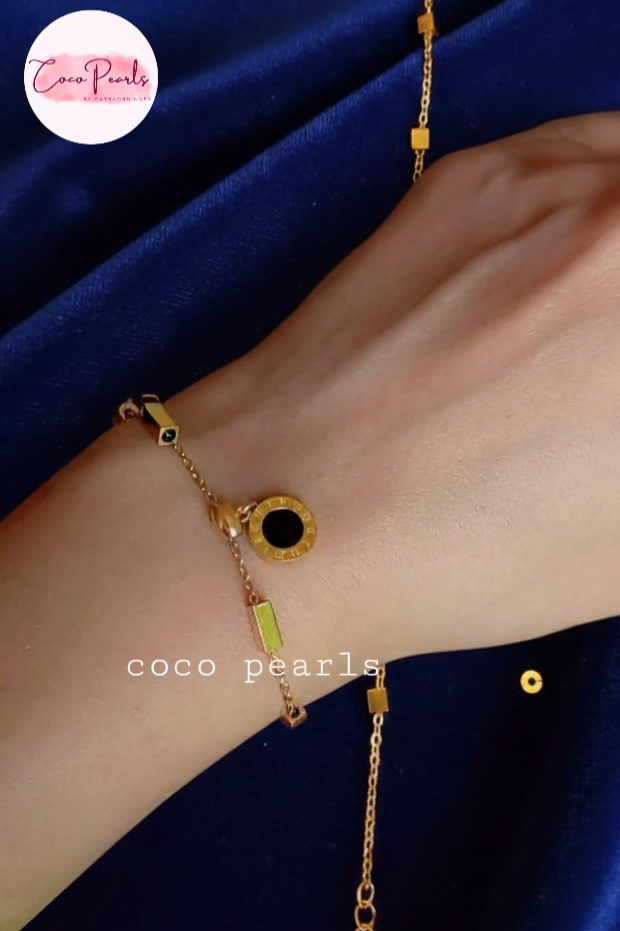 Coco Pearls Stainless steel anti tarnish Gold geometry bracelet with black gemstone hanging displayed on a white background,