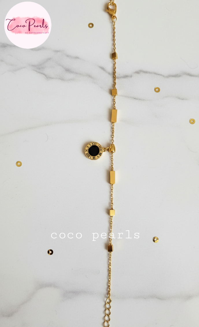 Coco Pearls Stainless steel anti tarnish Gold geometry bracelet with black gemstone hanging displayed on a white background,