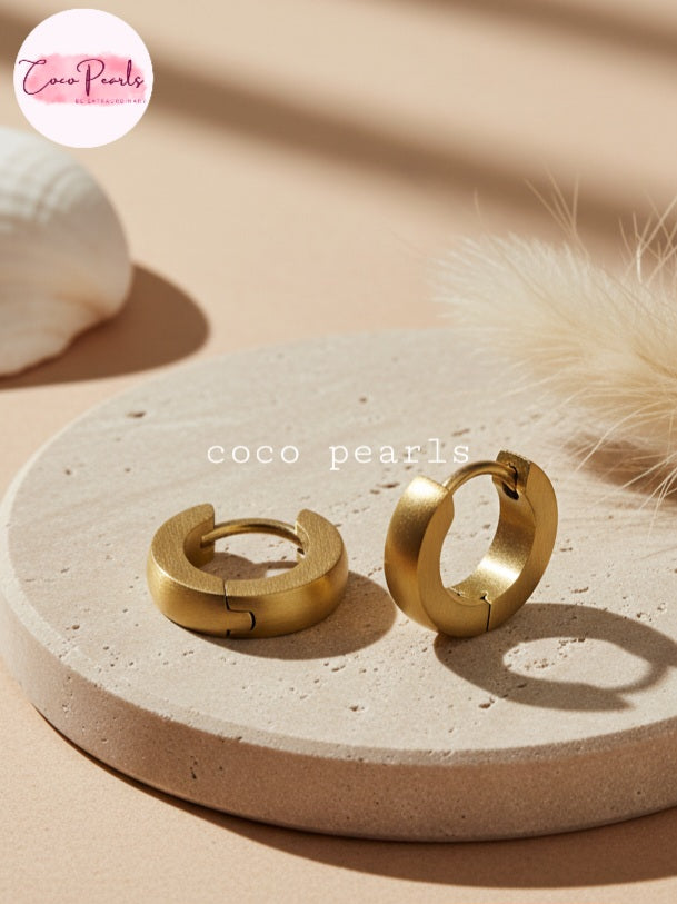 Coco Pearls Stainless Steel Anti Tarnish Golden barrel hoop earrings on a beige stone surface